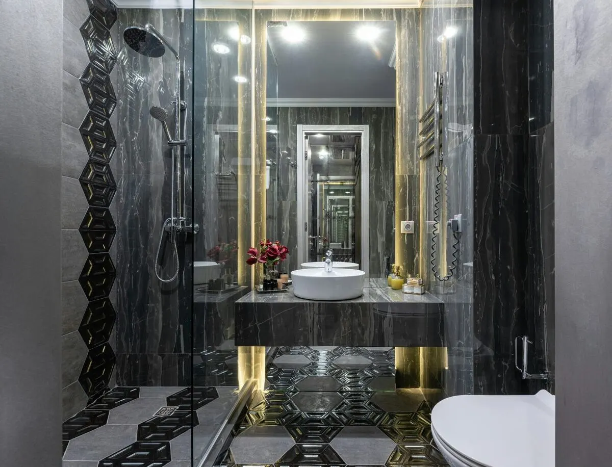 Black and white floral tile bathroom with glass walk in shower and skylight