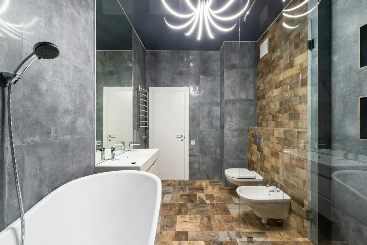 Industrial bathroom with concrete tile wood accent and sculptural chandelier
