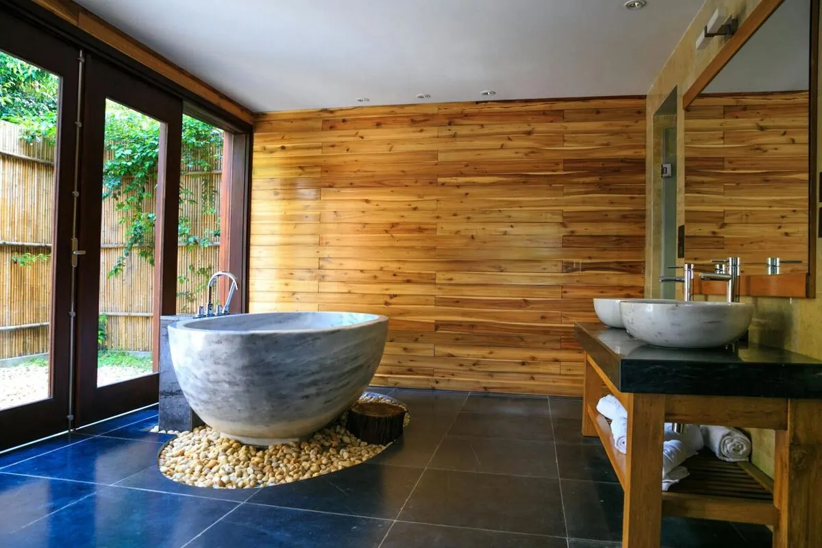 Zen spa bathroom with teak walls stone soaking tub and garden view
